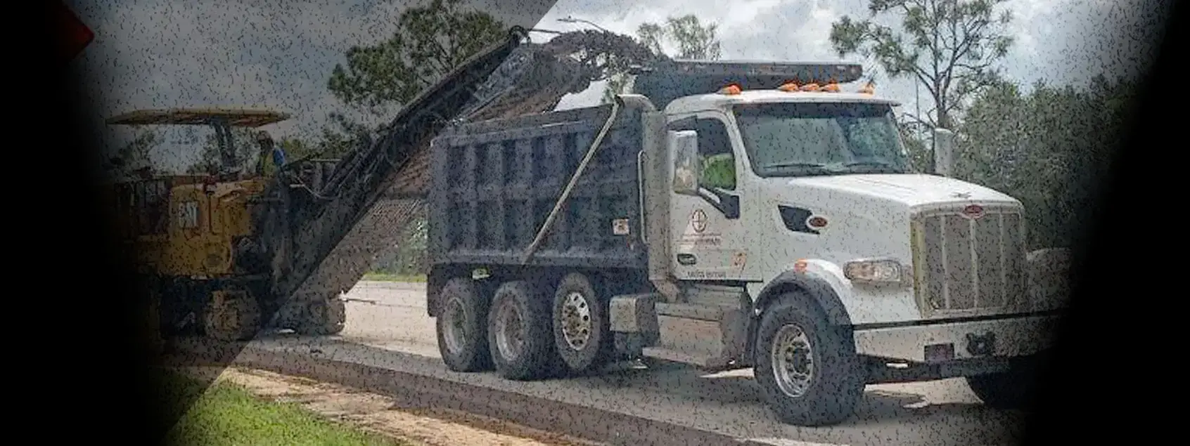 Ongrade milling machine loading a dump truck on a roadway project