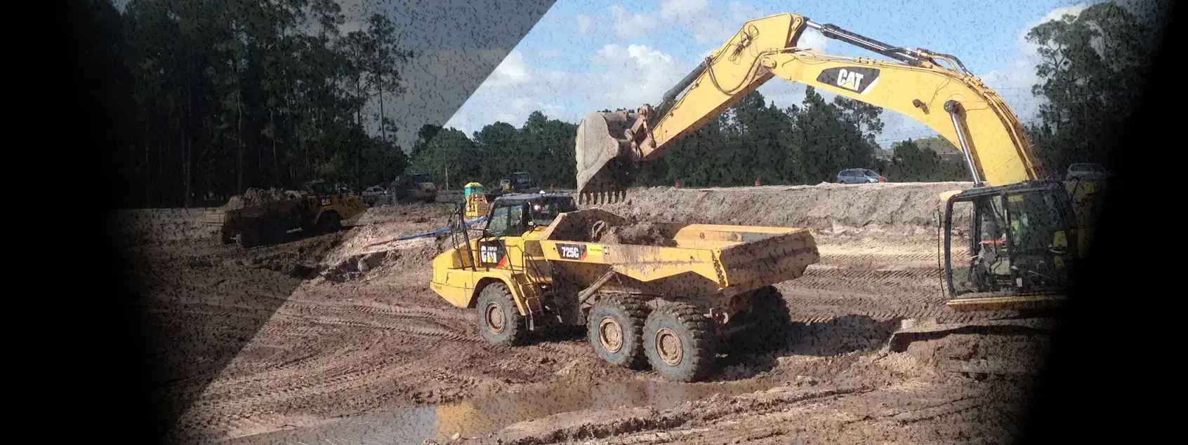 Ongrade excavator loading an articulated dump truck on a roadway project